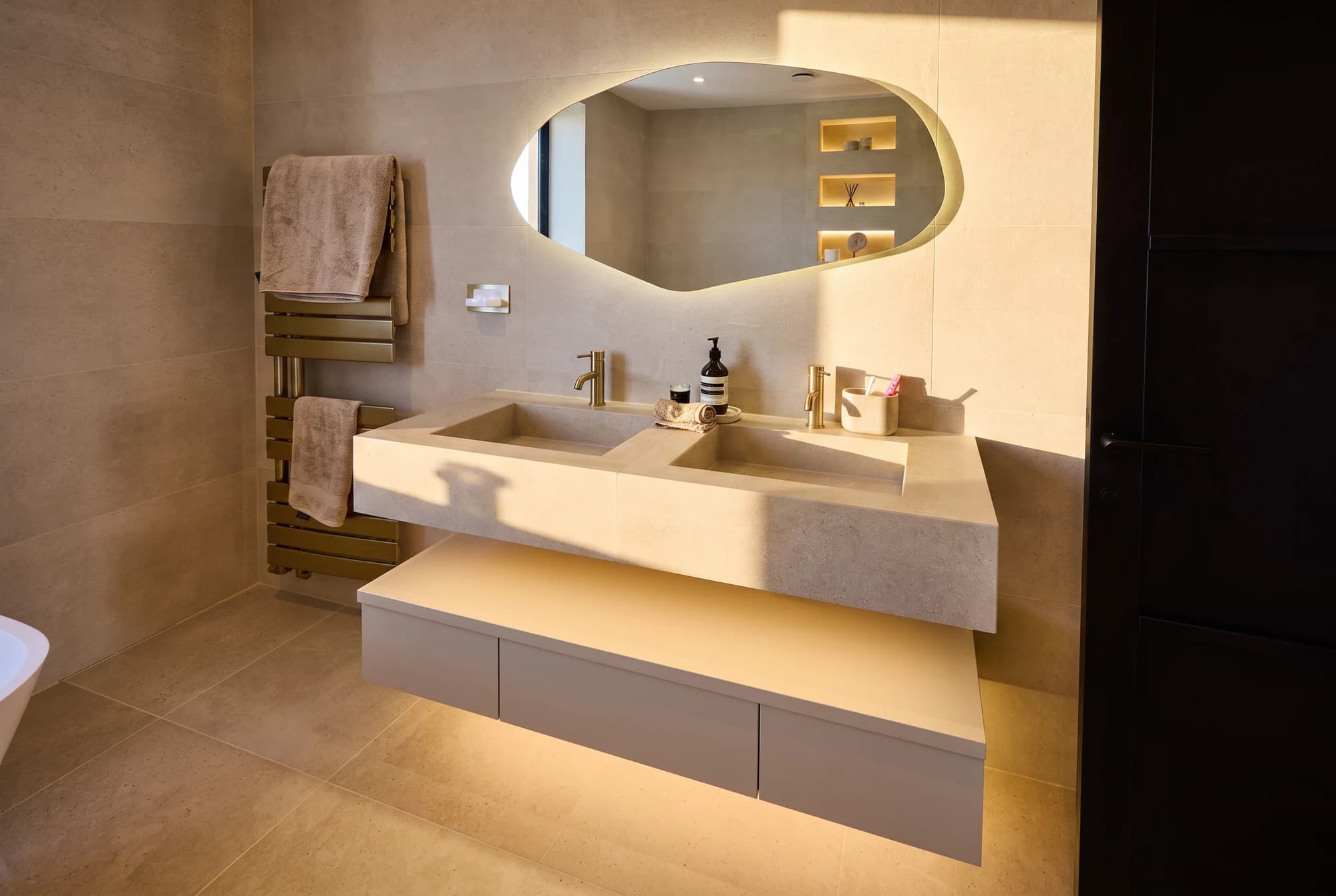 Double stone basin and organic mirror in golden natural light