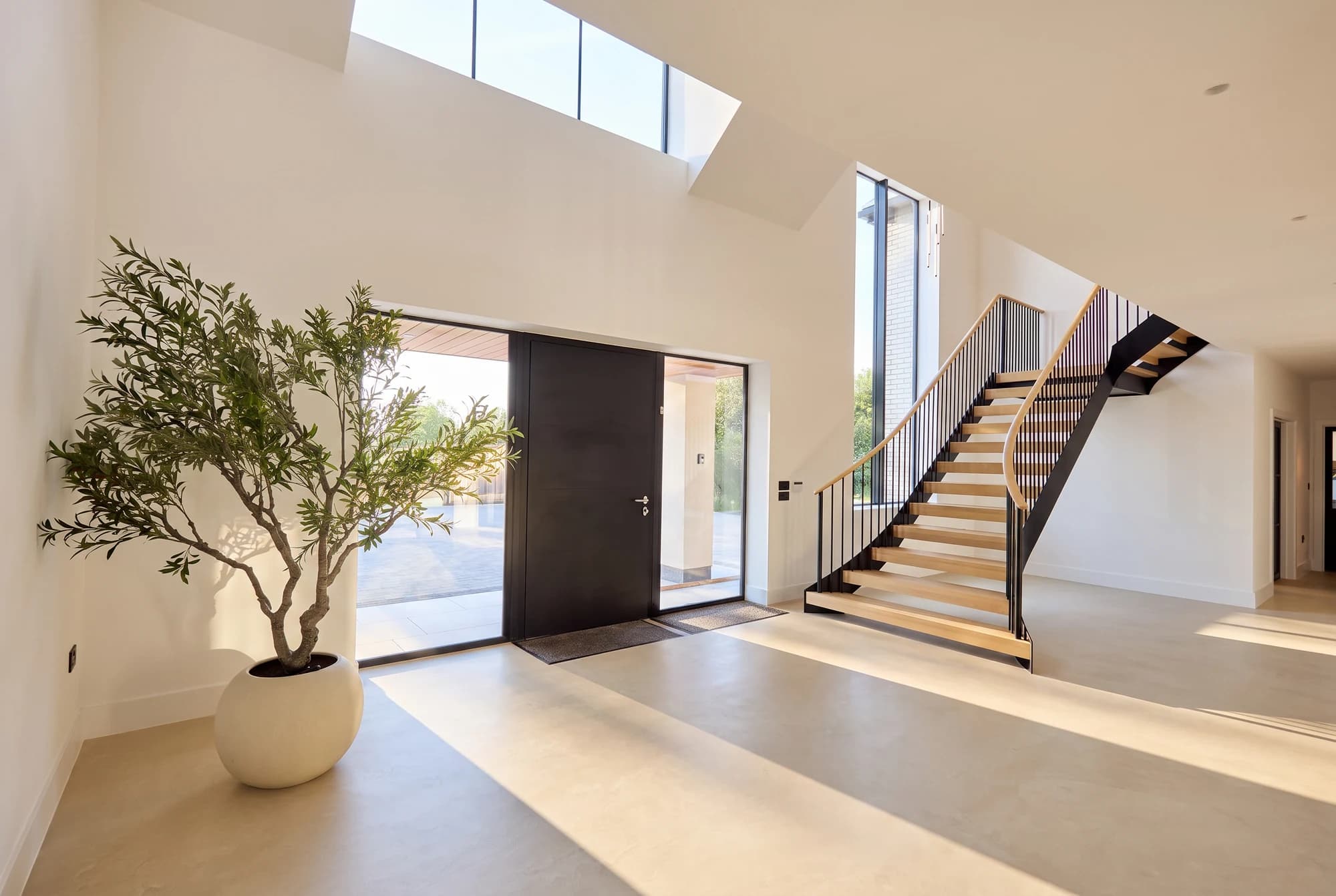 Double-height entrance hall with an open timber and steel staircase