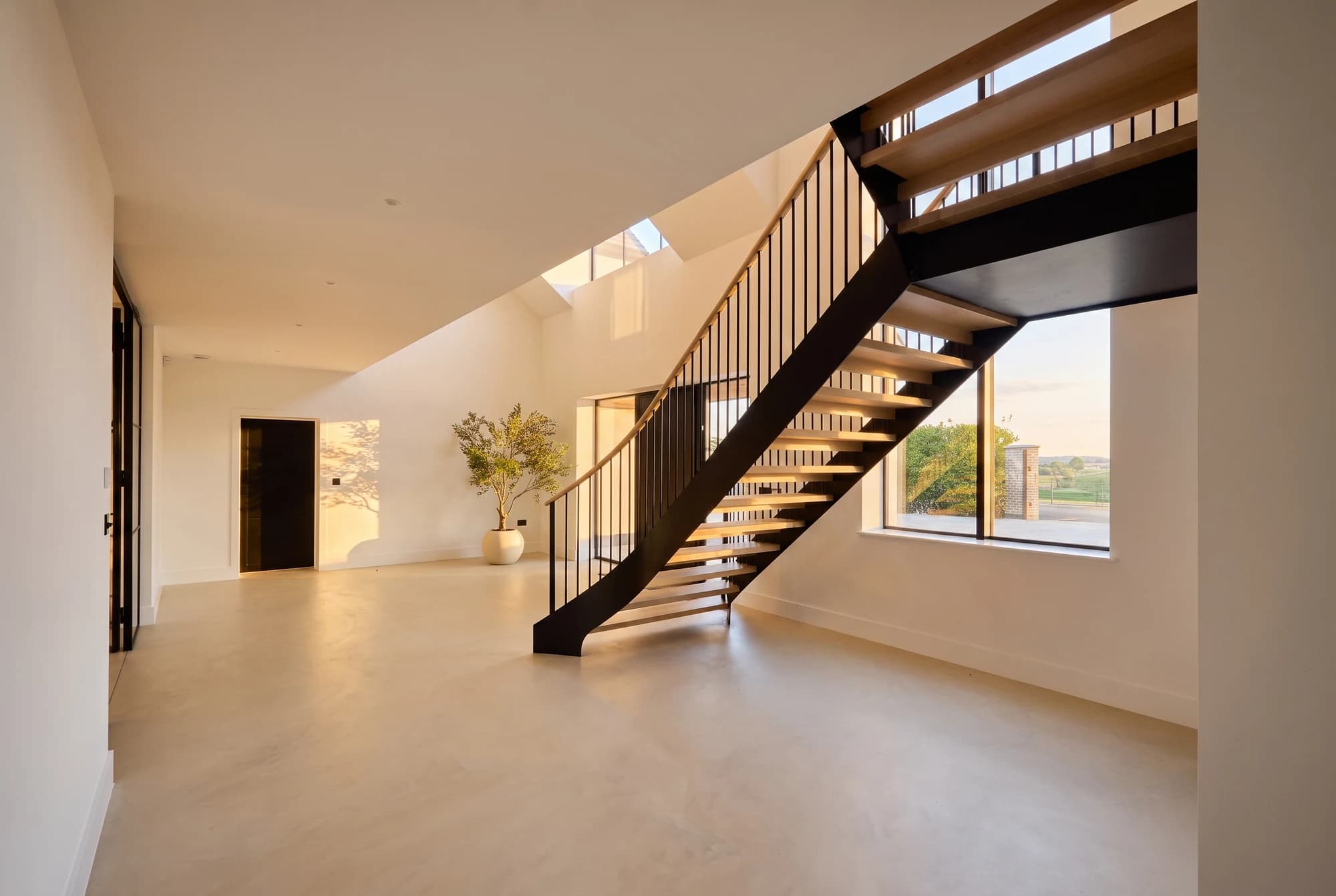 Open staircase and large windows in the warm evening light